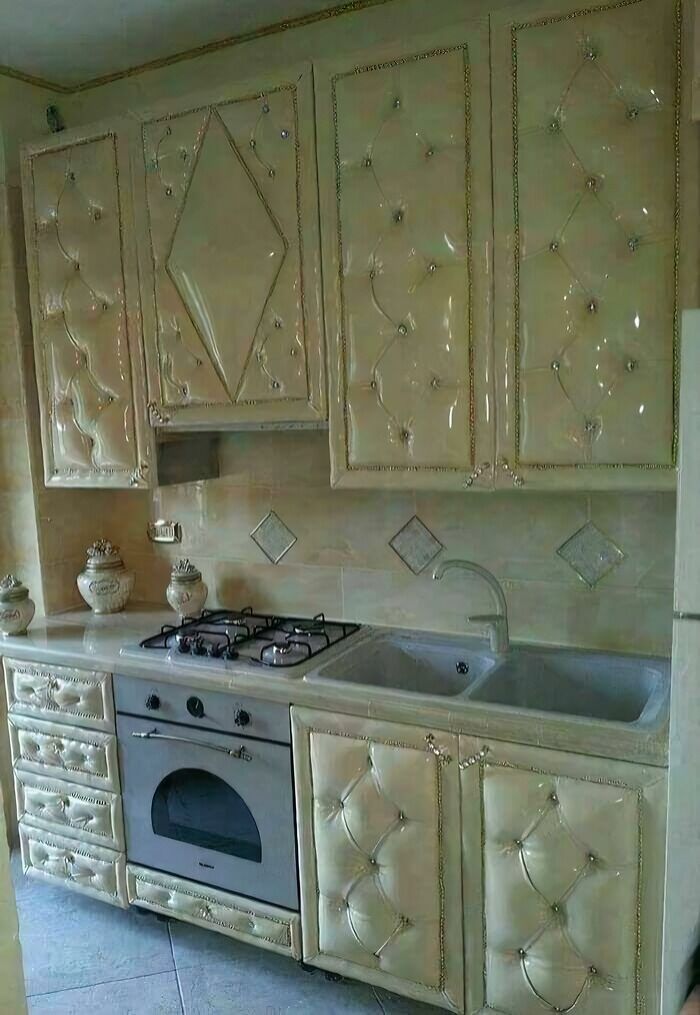 A kitchen with unusual, upholstered cabinets, demonstrating a unique construction fail.