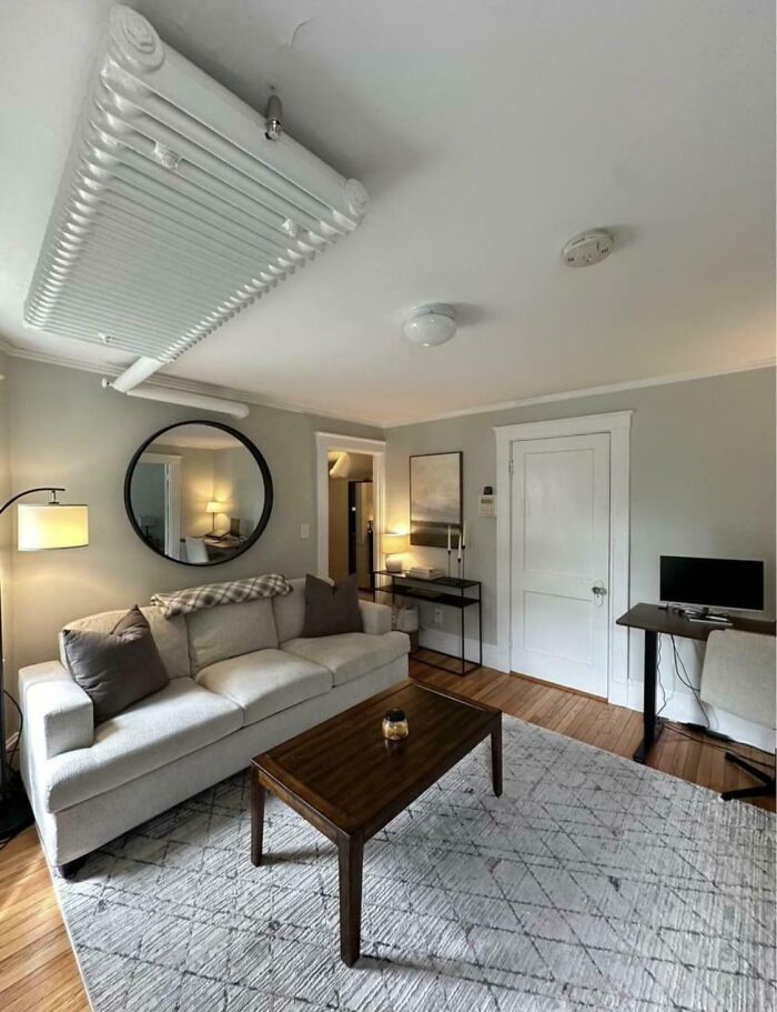 A construction fail shows an awkwardly placed heating unit on the ceiling of a living room.