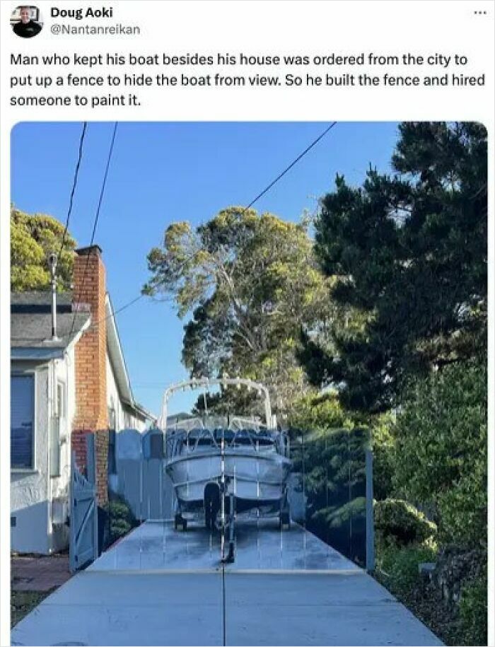 A boat on a trailer, painted to match a fence, a clever act of petty revenge against city orders.