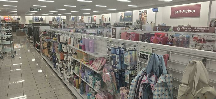 An aisle in a department store filled with various consumer goods, illustrating the vastness of consumerism.