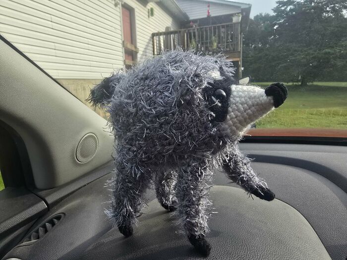 Crochet animal figurine made of fuzzy yarn on car dashboard
