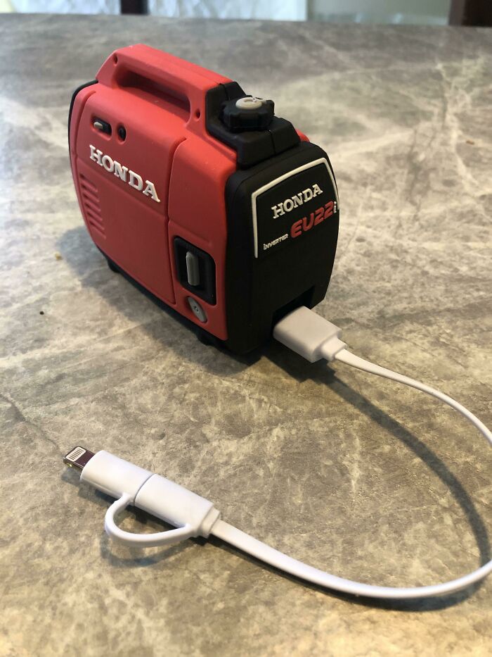 A miniature red Honda generator that designers transformed into a phone charger, making ordinary things enjoyable.