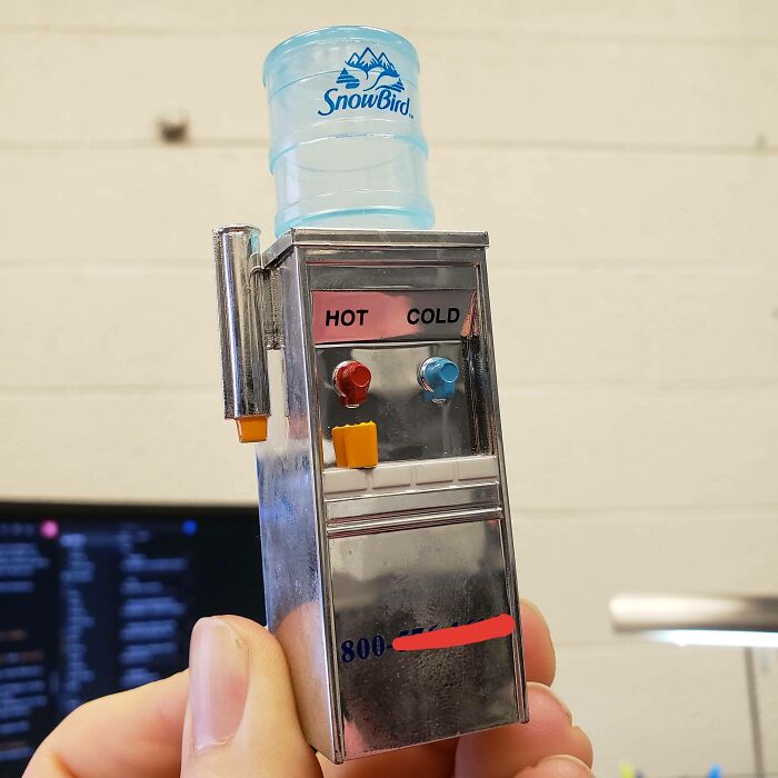 A miniature SnowBird water cooler with hot and cold buttons, demonstrating brilliant design in a small, ordinary object.