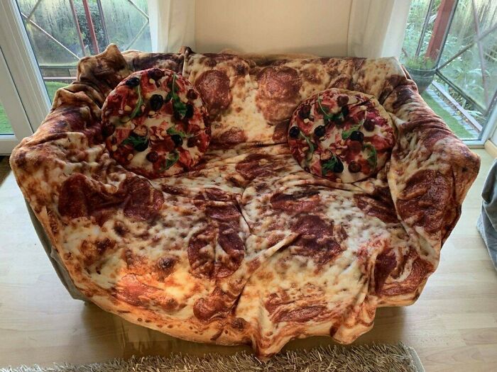 A sofa covered in a pizza-themed blanket and cushions, a brilliantly transformed ordinary thing for enjoyment.