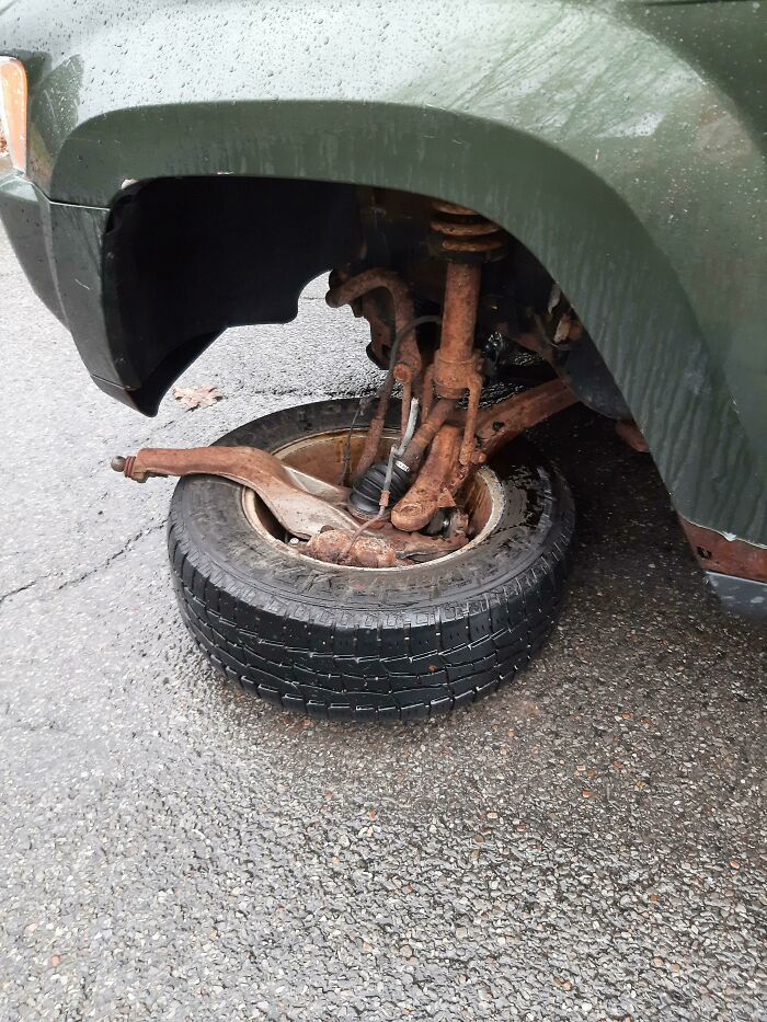 A car tire detached from the axle on a wet road. Someone is having a worse day.