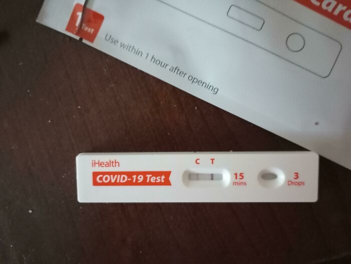 A positive COVID-19 test result on a dark surface, indicating a way worse day.