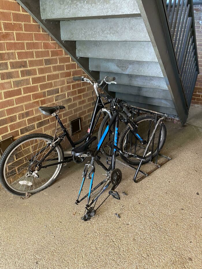 Two damaged bicycles under an outdoor staircase. Someone is having a worse day.