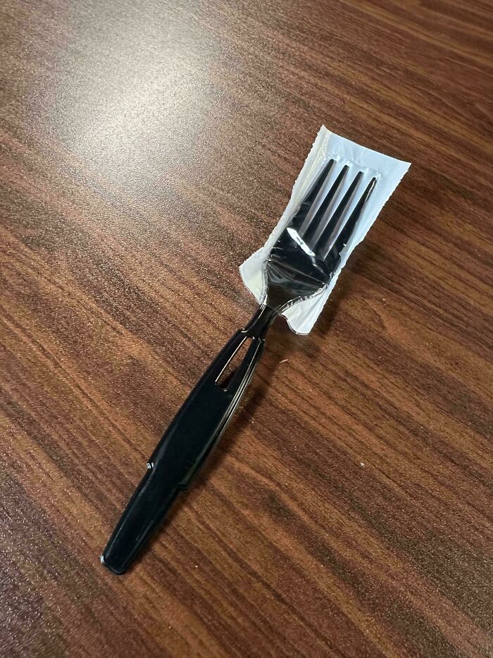 A cleverly designed black fork with an integrated plastic sleeve, enhancing usability of ordinary things.