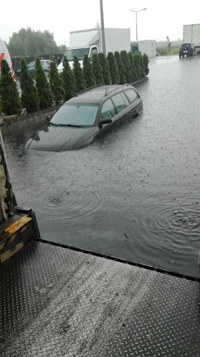A car submerged in floodwaters, clearly having a worse day.
