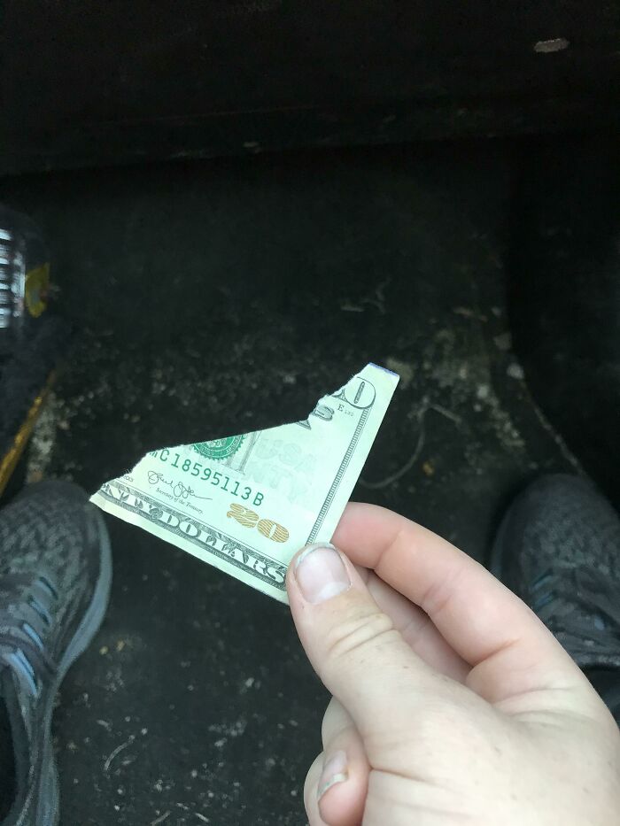 A person holding a torn twenty-dollar bill, highlighting a person having a worse day.