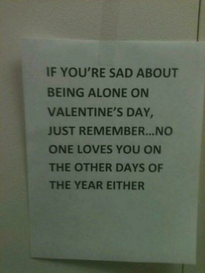 A hilariously failed sign offering dark humor, stating no one loves you on other days either if sad about Valentine's Day.
