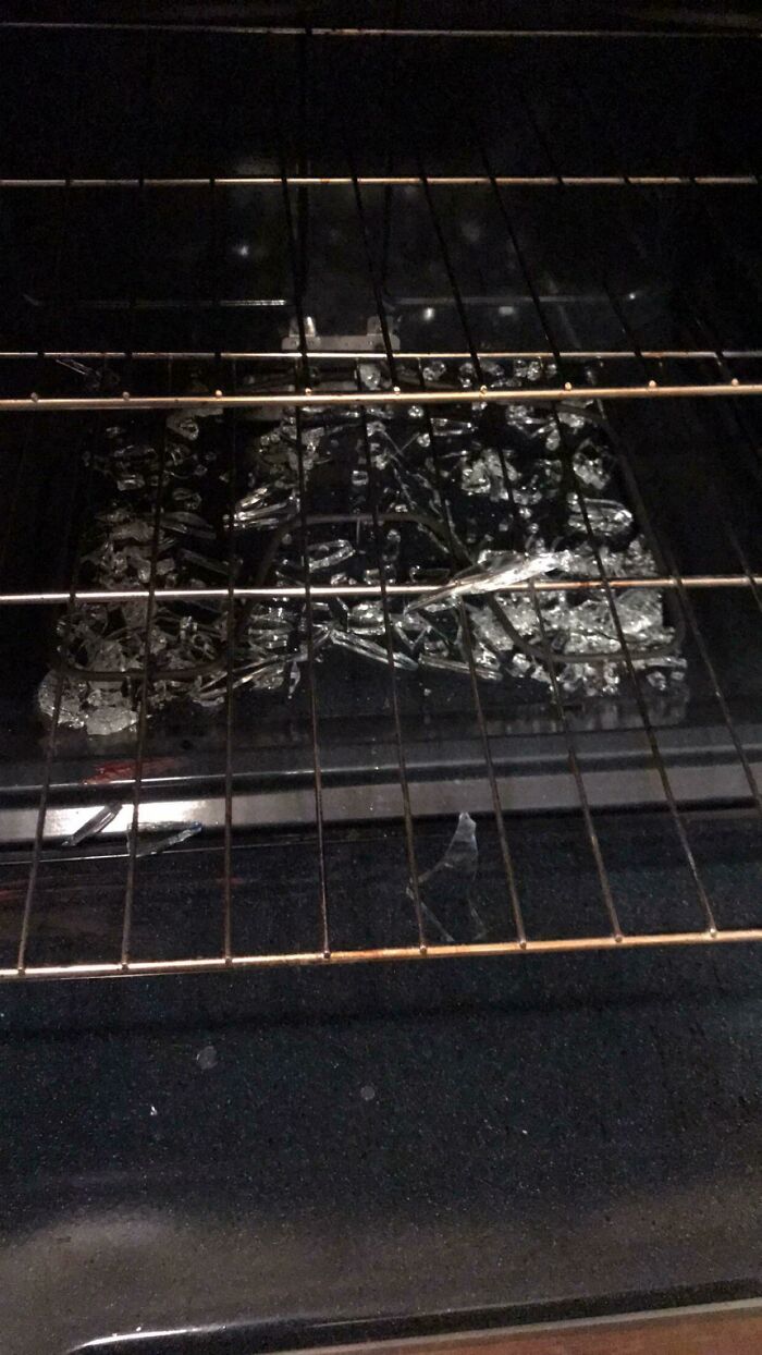A person having a worse day, a broken glass dish shattered inside an oven on a rack.