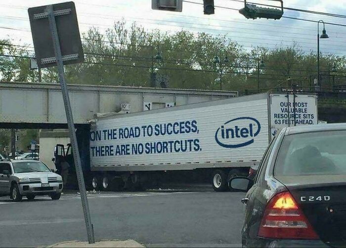An Intel truck with 'No shortcuts' text stuck under a low bridge, a hilarious sign failure.
