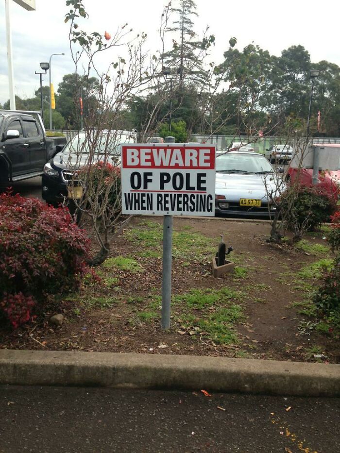 A hilariously failed sign warning to beware of a pole, with the signpost itself being the pole.