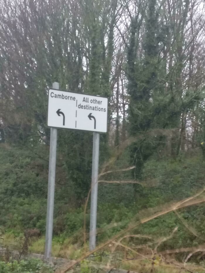 A road sign pointing both left and right for Camborne and all other destinations, hilariously failed at providing clear direction.