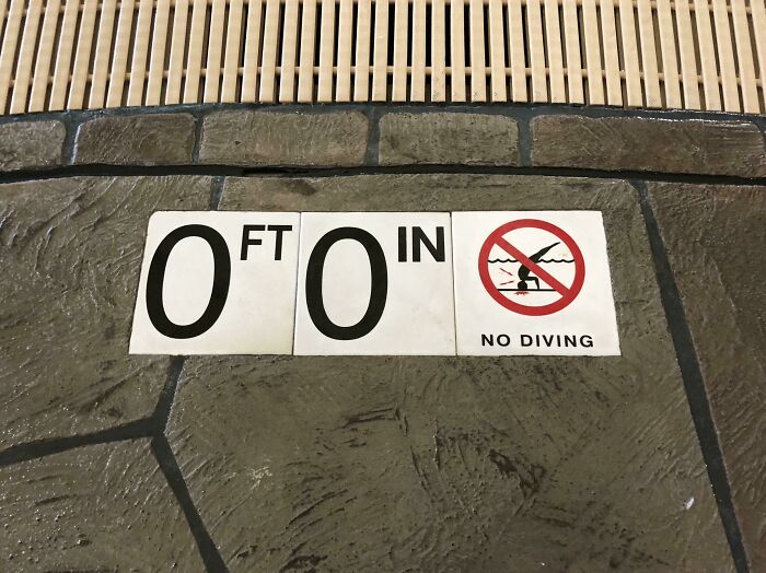 A hilariously failed sign at a pool with 0ft 0in depth, warning NO DIVING.