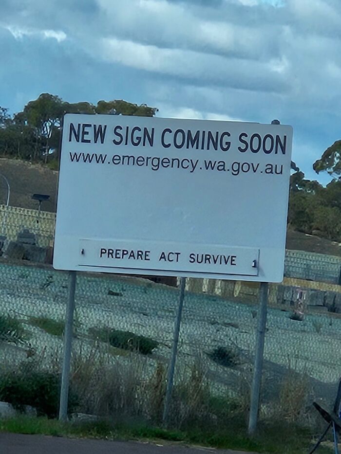 A hilariously failed sign with the text NEW SIGN COMING SOON above a landscape with hills and a cloudy sky.