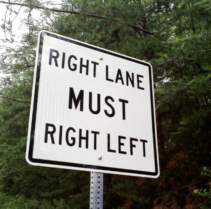 A road sign that hilariously failed its purpose, reading 'Right Lane Must Right Left' against a background of trees.