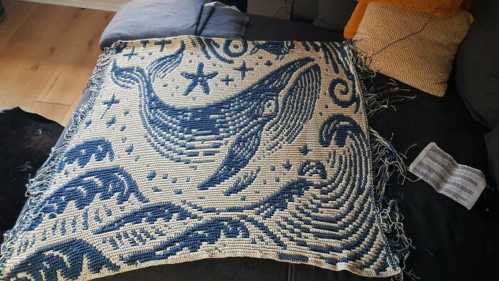 Blue and white crochet blanket featuring a large whale and starfish design