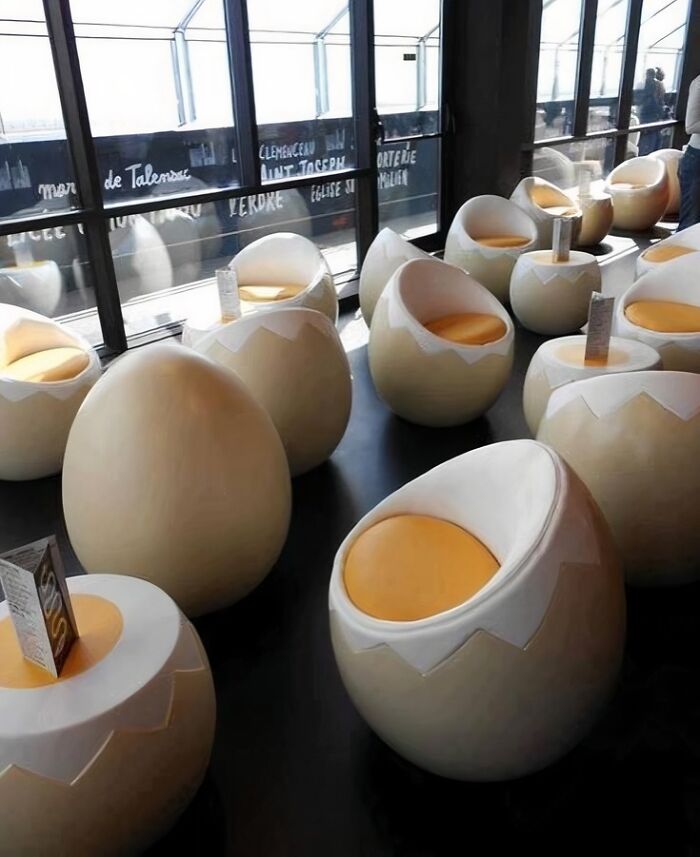 Egg-shaped chairs with yellow cushions in a modern setting, an enjoyable design transforming ordinary seating.