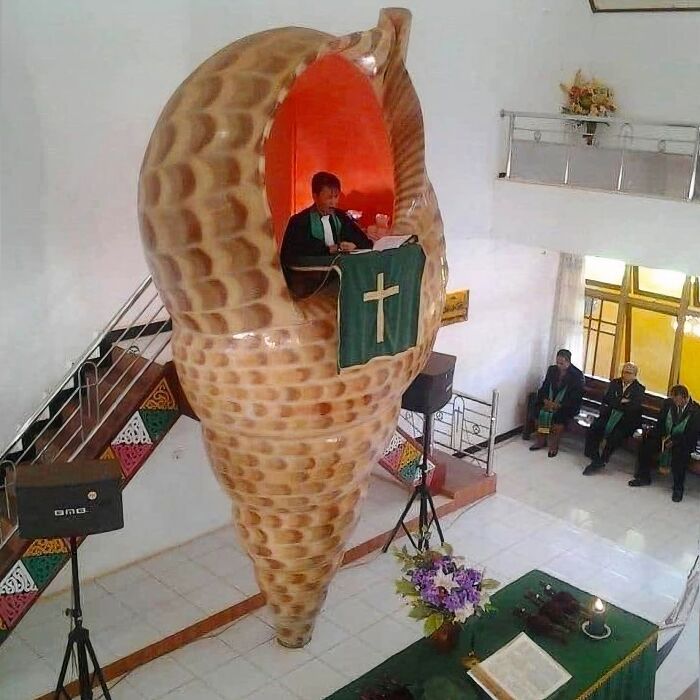 A preacher delivers a sermon from a pulpit shaped like a giant seashell, brilliantly transforming ordinary things in a church.