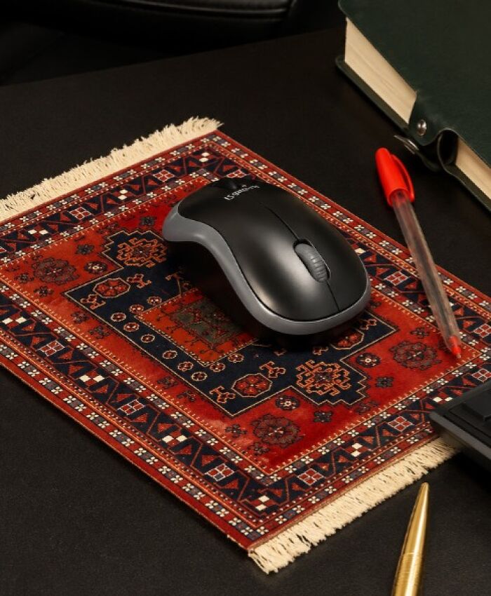 A computer mouse rests on a miniature Persian rug mousepad, an example of designers transforming ordinary things.