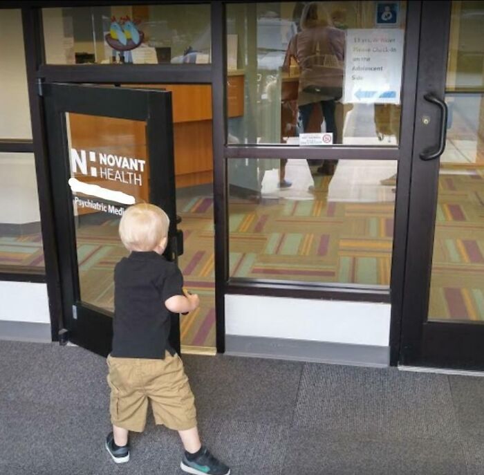 A small child standing in front of a glass door with a large Novant Health logo, illustrating a transformed space that is more enjoyable.