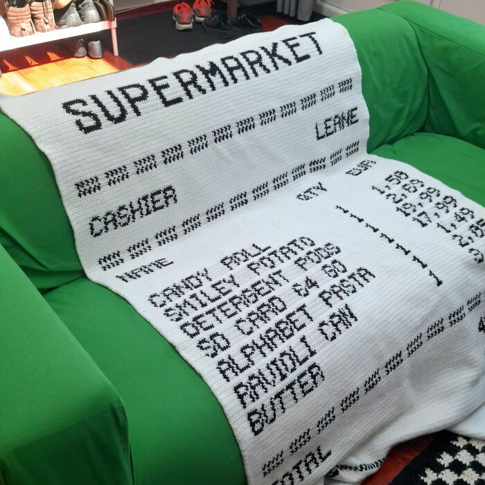Crochet blanket mimicking a supermarket receipt with black text on white yarn