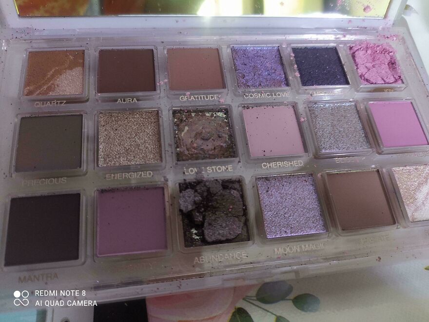An eyeshadow palette with several broken and spilled colors, an expensive mistake of damaged makeup.