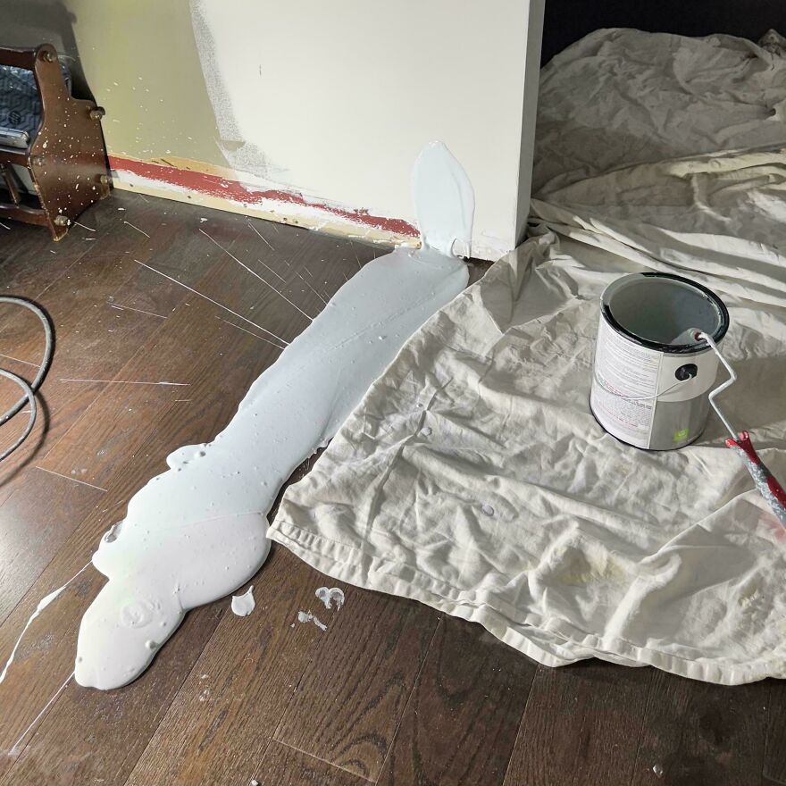 An expensive mistake: A large spill of white paint on a wooden floor and drop cloth, a common accident.