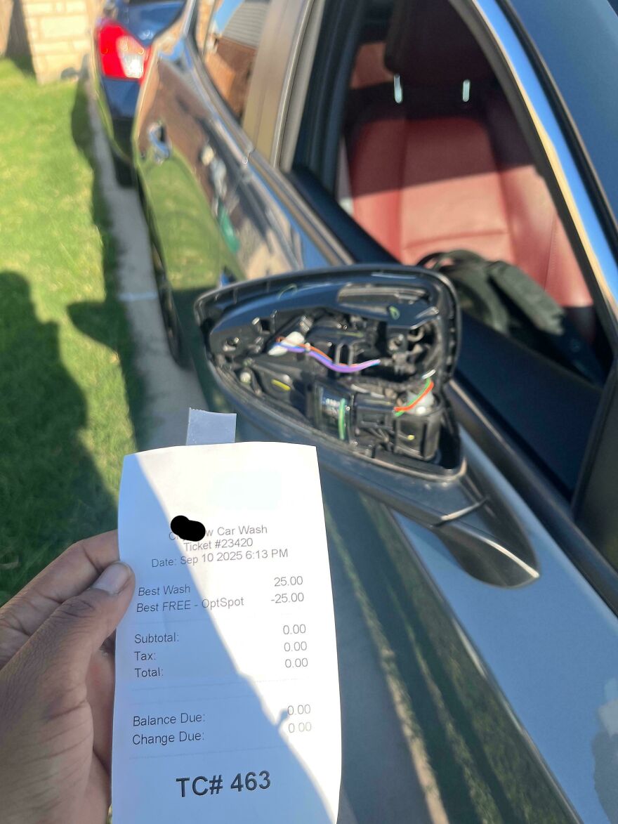 A hand holding a car wash receipt next to a car with a broken side mirror, an expensive mistake.