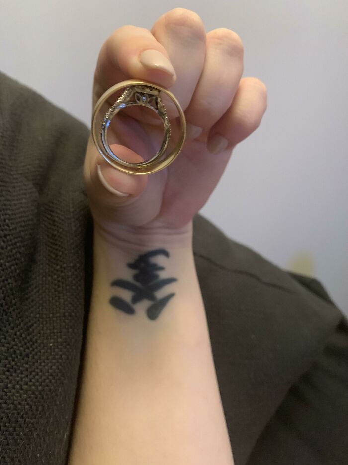 A hand holding a large ring, demonstrating a size comparison to a finger, highlighting true scale.