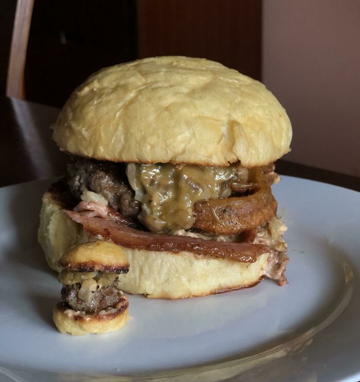 A huge burger next to a tiny mini-burger, illustrating a significant size comparison and true scale.