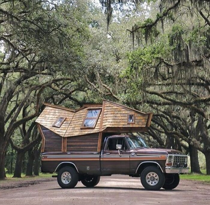 A unique house-like structure built on the back of a truck, demonstrating brilliant design choices.