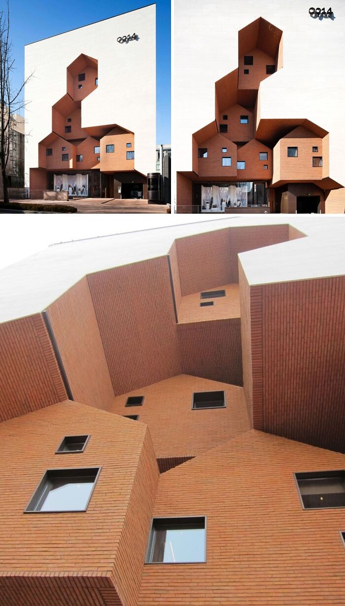 Brilliant design choices in a building with multiple small, stacked brick houses protruding from a white facade.
