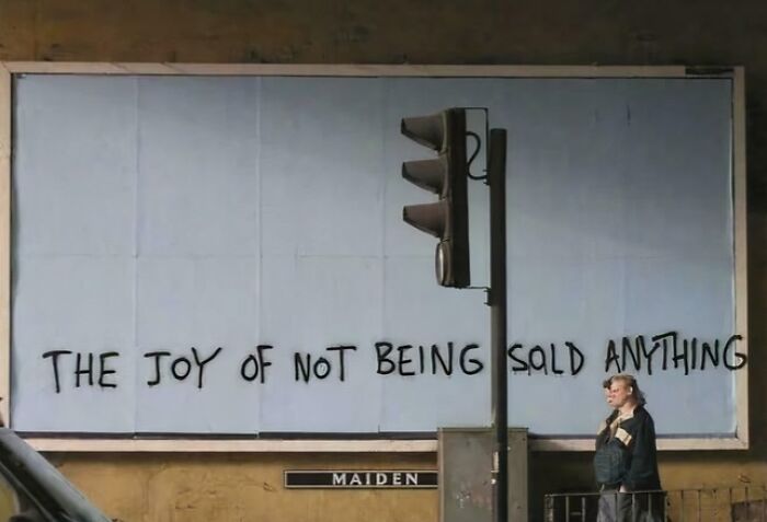 A billboard with the phrase The joy of not being sold anything, commenting on consumerism and price difference.