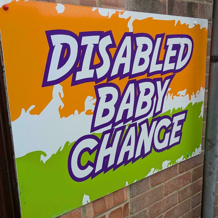 A sign with hilariously awful design that reads DISABLED BABY CHANGE with poor kerning on the words.