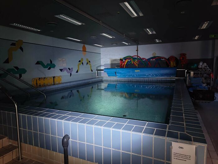 Urban explorers uncovered a small, dimly lit indoor pool with blue tiles and rescue equipment, an unexpected discovery.