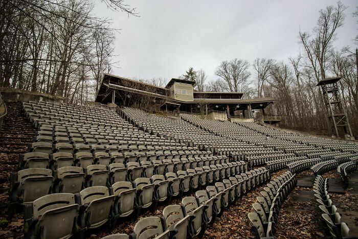 Urban explorers found an abandoned outdoor amphitheater with rows of empty seats and bare trees.