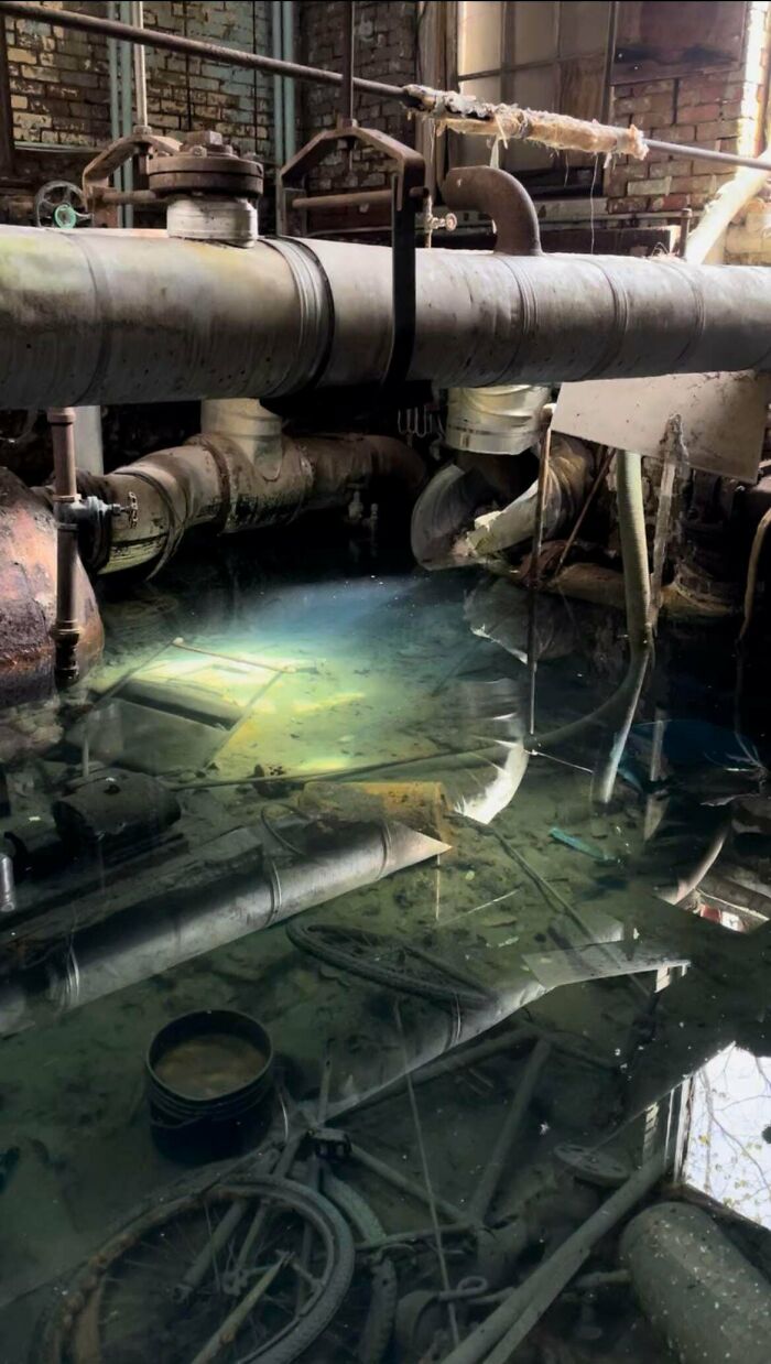 Urban explorers discover a flooded industrial area with murky water, old pipes, and submerged debris, revealing unexpected finds.