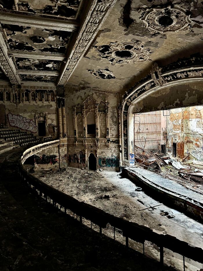 Urban explorers finding a dilapidated, empty theater with peeling paint and graffiti, showcasing unexpected finds.