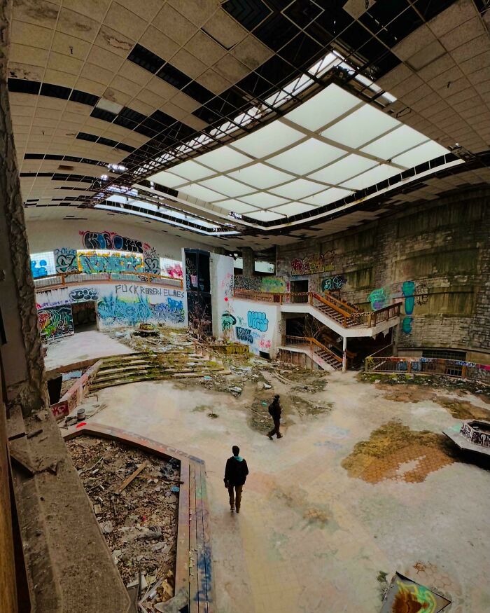 Urban explorers found a graffiti-covered, abandoned building with two figures in the vast, decaying space.