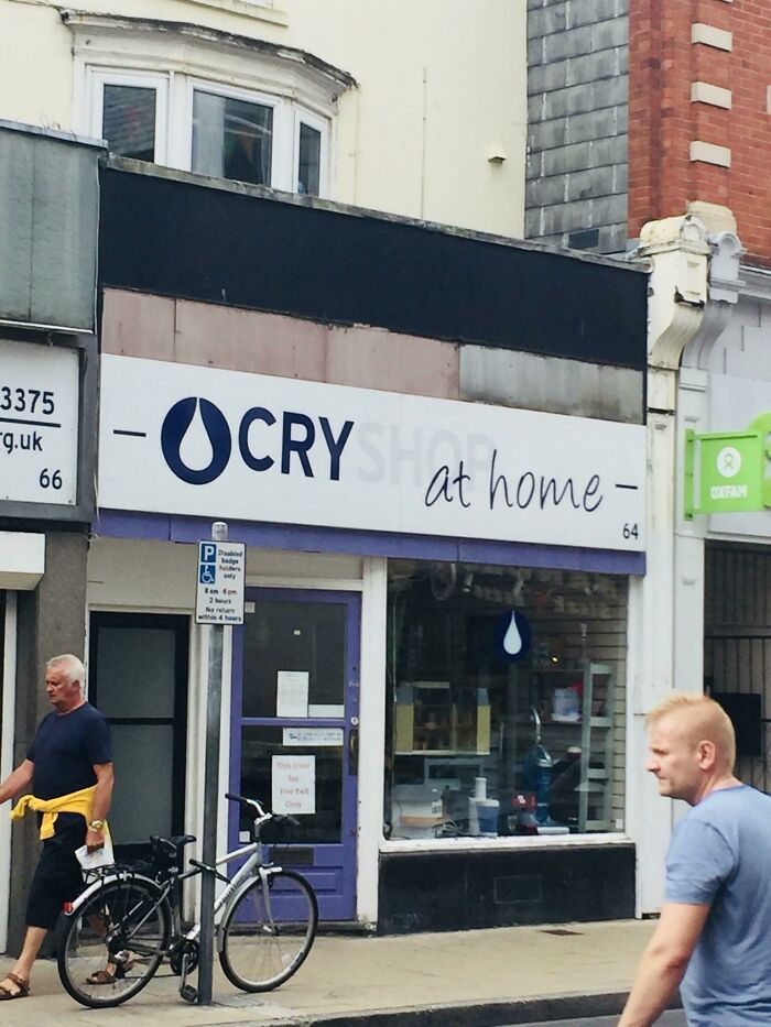 An awful design fail for a storefront sign that reads OCRY SHOP at home with a tear drop logo.