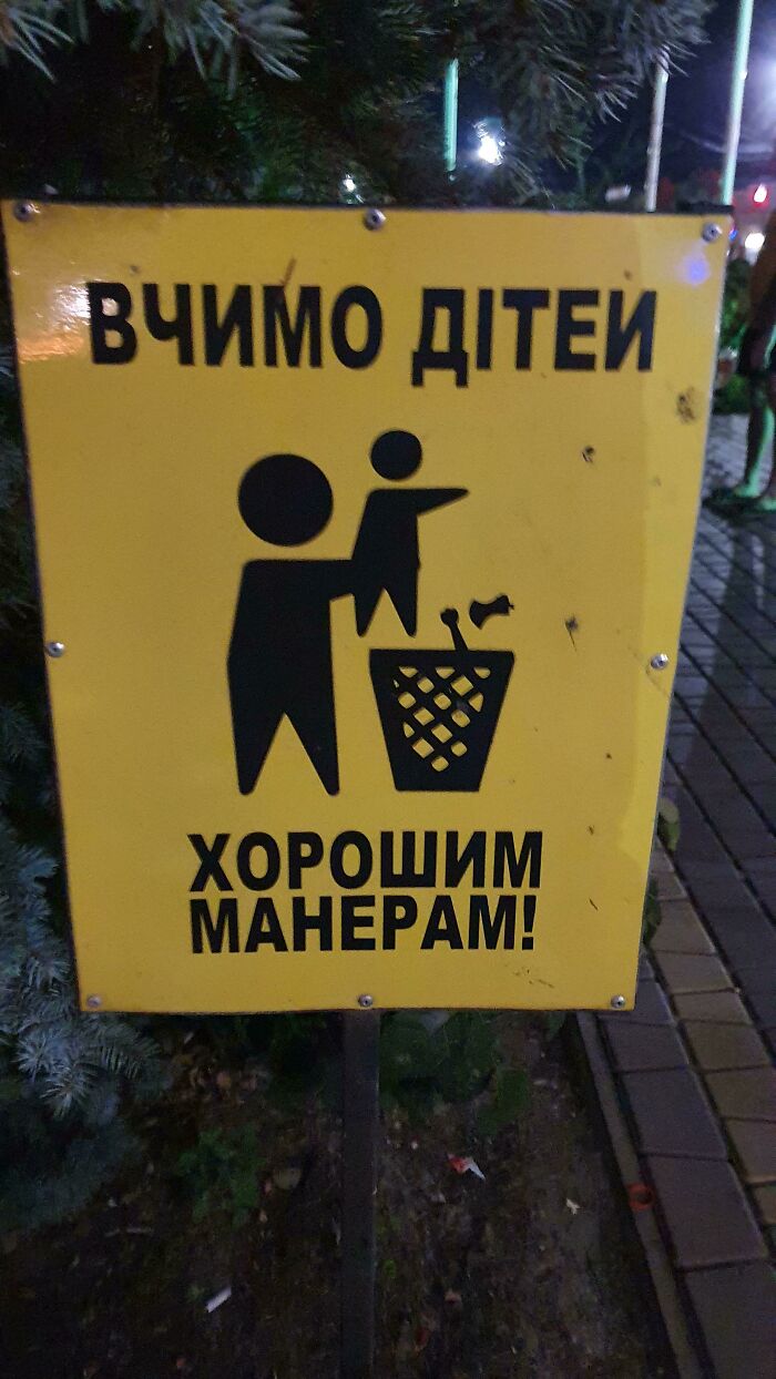A yellow sign depicting a person throwing a child into a trash can, an awful design fail.