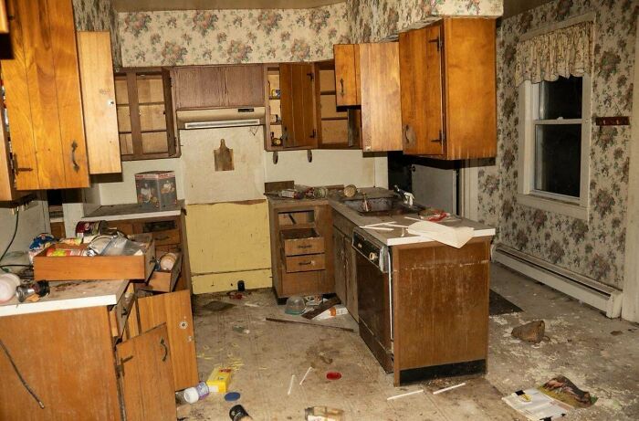Urban explorers discovered an unexpectedly messy and abandoned kitchen with fallen cabinets and debris scattered on the floor.