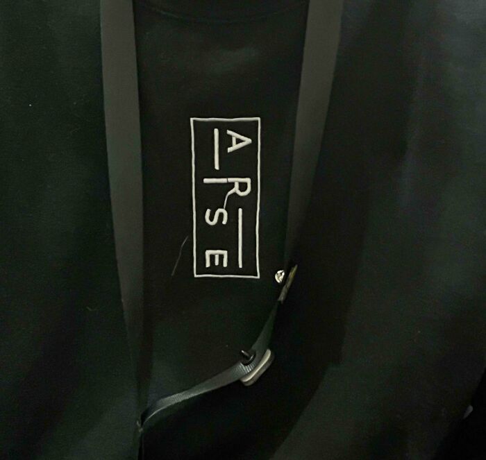 A black shirt with the word 'A**E' printed on it, highlighted as a hilarious design fail.