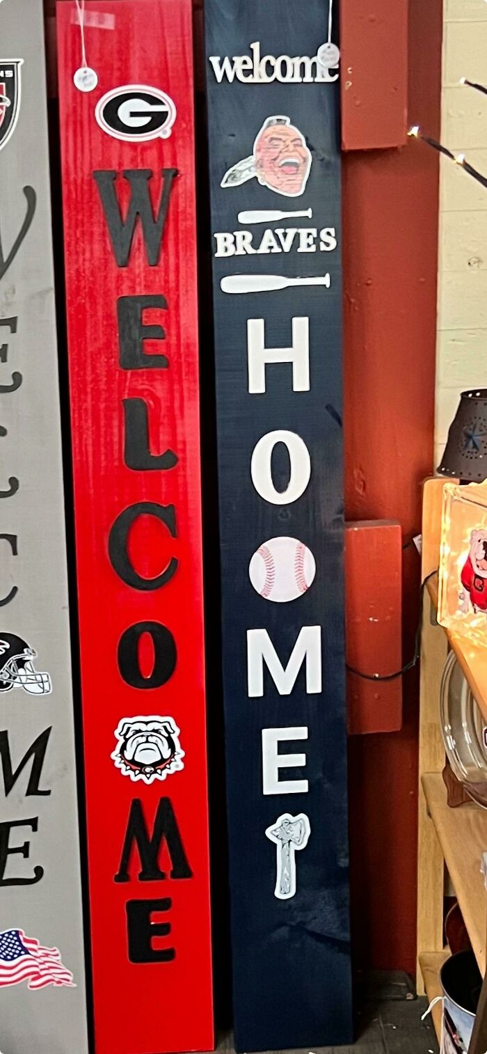 Two welcome signs with sports themes, one red and one blue, displaying awful design fails.