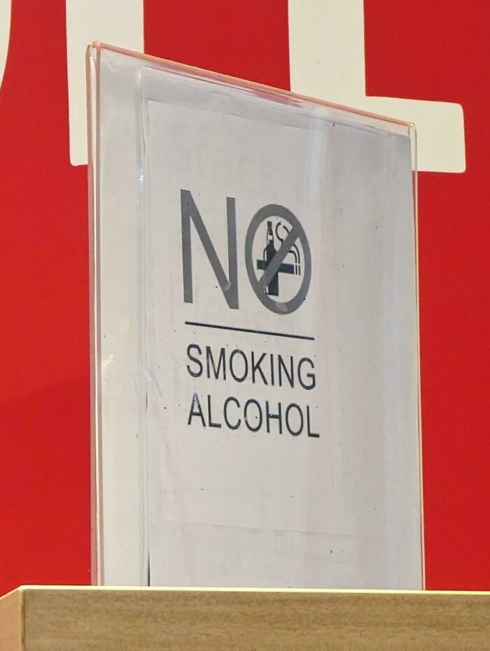 A hilariously awful design fail with a sign that reads NO SMOKING ALCOHOL, poorly designed.