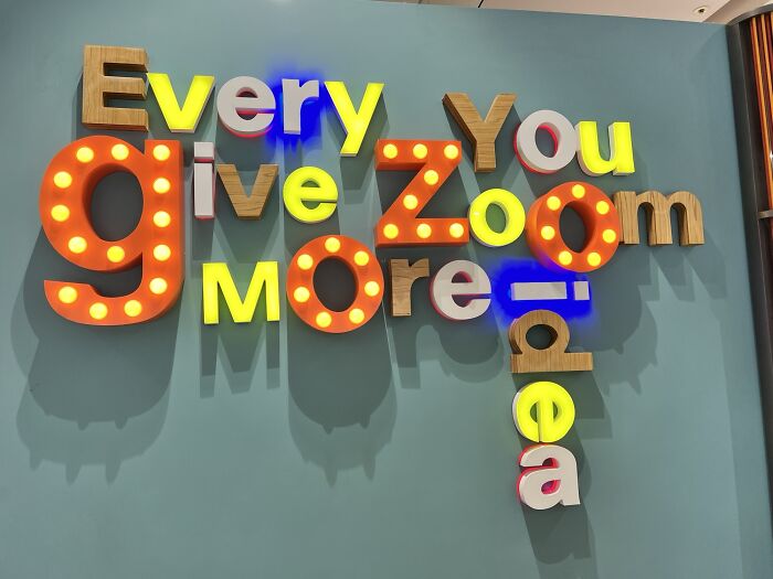 A wall art display with jumbled words in different fonts and lights, a hilariously awful design fail.