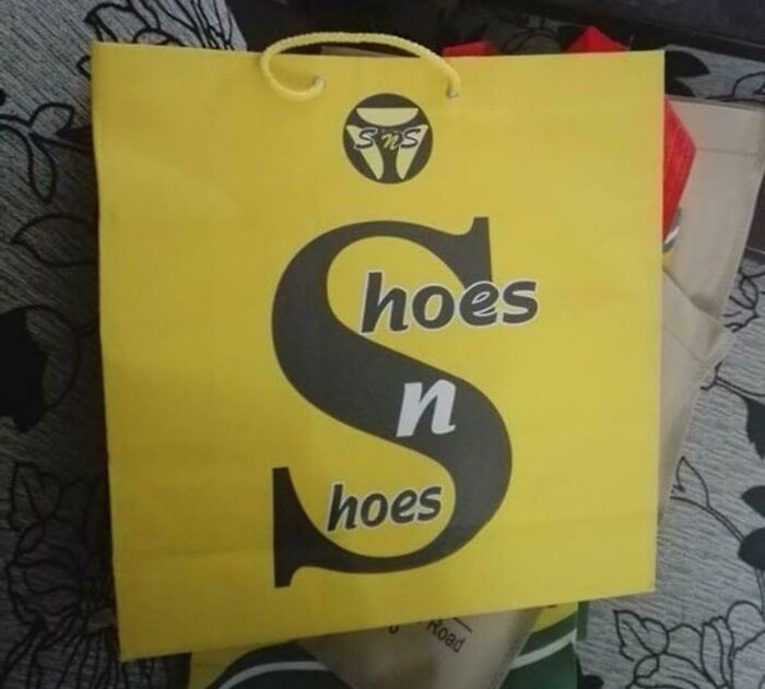 A yellow shopping bag with black lettering that reads Hoes n Shoes, a hilariously awful design fail.